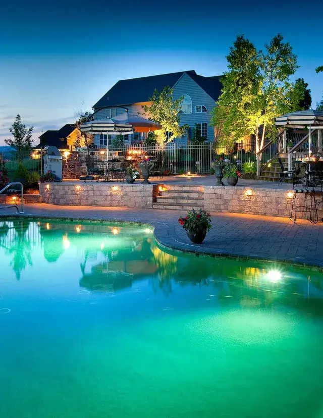 A pool surrounded by beautiful landscaping and lighting